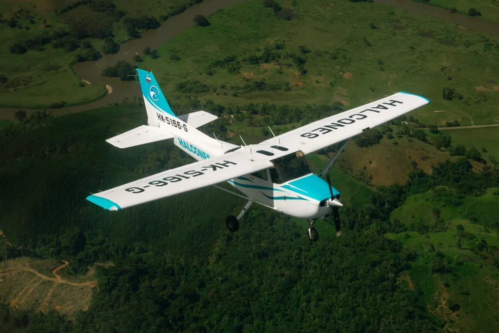 Avión de entrenamiento de Halcones Aviation School en vuelo, utilizado en la formación de pilotos comerciales en Colombia.
